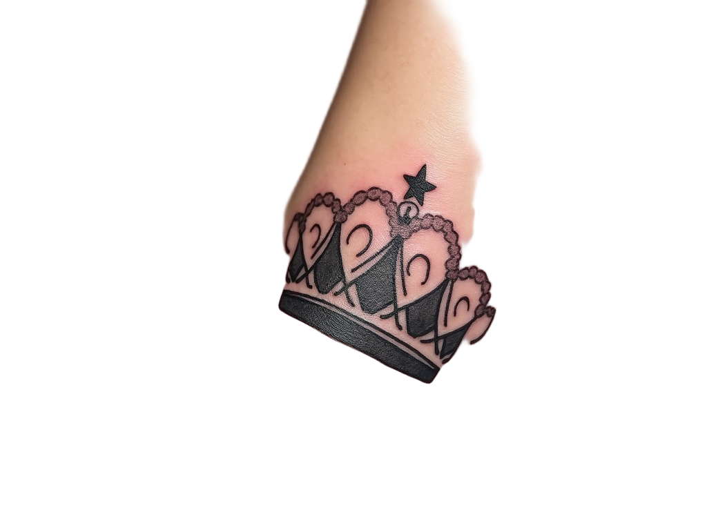 A crown tattoo charm, inked on the ankle, portraying elegant swirls and a tiny star on top, evoking themes of royalty and magic.